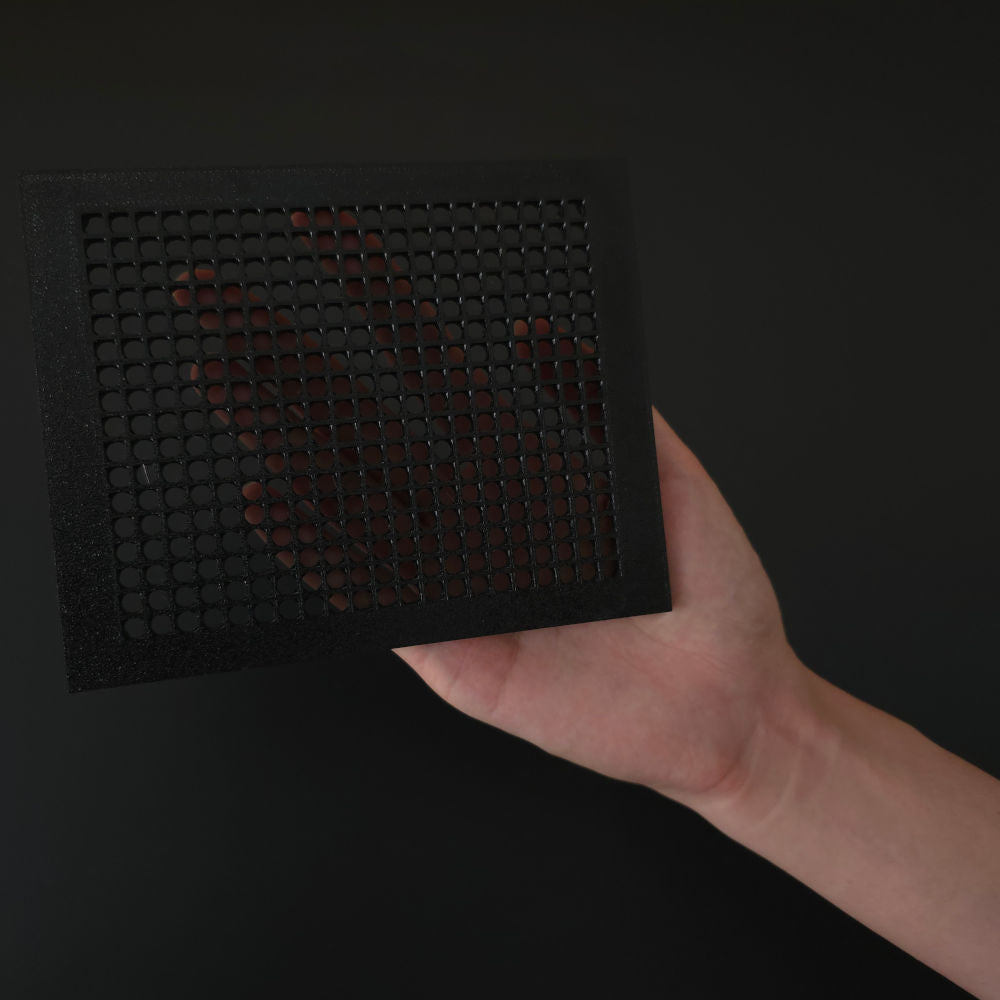 A hand holding a empty BitPlate faceplate